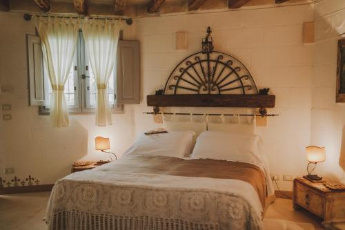 a bedroom with a large bed and two windows at Masseria Montenapoleone in Fasano