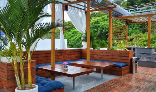 a patio with two tables and a bench at The Wind Mountainside Hotel in Vung Tau