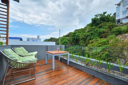 a patio area with chairs, a table, and a balcony at The Wind Hotel - Spa Inclusive in Vung Tau
