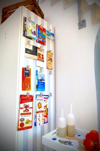 a white refrigerator with posters and bottles on a wall at Kieler FeWo No.1 in Kiel