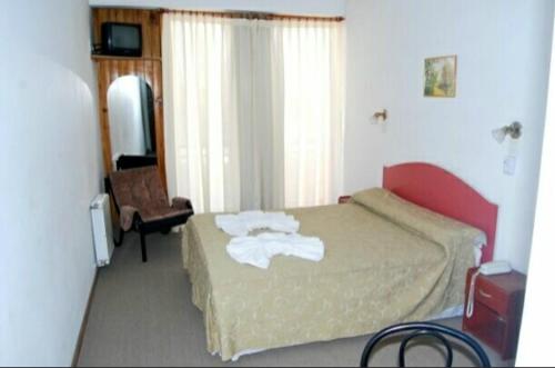 a hotel room with a bed with towels on it at Hotel Fantilli in Puerto Madryn