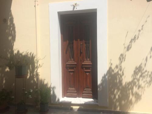 a wooden door on a building with a shadow at Nikos and Eva Studios in Symi