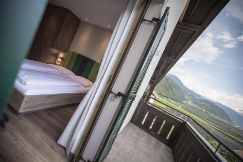 a bedroom with a bed and a view of a mountain at Hotel Garni Andrianerhof in Andrian