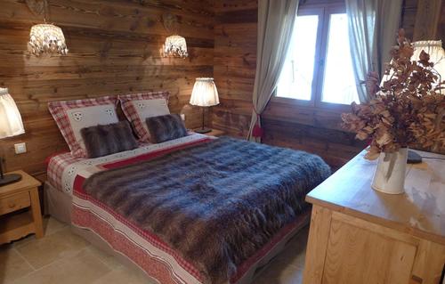 - une chambre avec un lit et un mur en bois dans l'établissement Odalys Chalet Les Alpages, à Les Deux Alpes