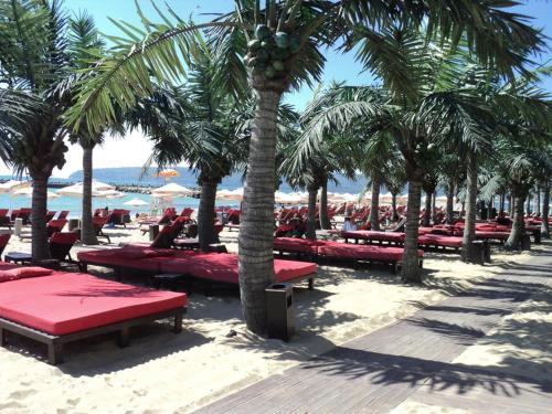 einen Sandstrand mit Palmen und roten Bänken in der Unterkunft Hostel Rayska Yabalka in Warna