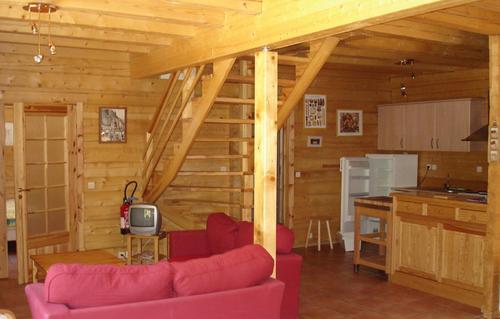 - un salon avec un canapé rouge dans une cabine dans l'établissement Odalys Chalet Le Pleynet, à Vénosc