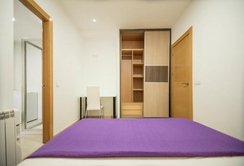 1 dormitorio con cama morada y armario en EnjoyGranada GRAN VIA B-A & Parking opcional, en Granada
