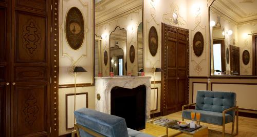 a living room with a fireplace and a blue chair at Axel Hotel Madrid - Adults Only in Madrid