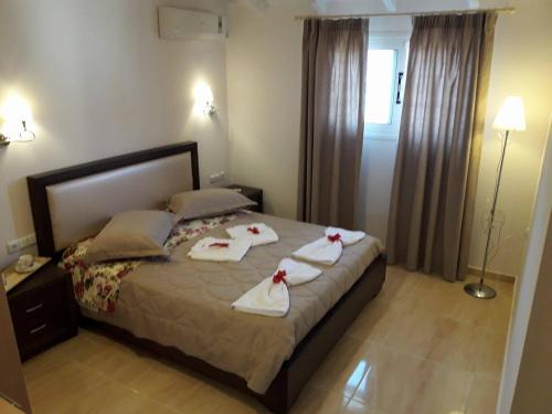 a bedroom with a bed with towels on it at Mazis Apartments in Agios Gordios