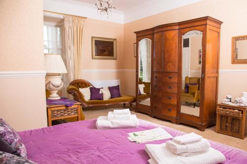 a bedroom with a purple bed and a dresser at Priskilly Forest Country House in Fishguard
