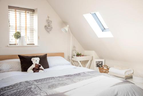 a bedroom with a teddy bear sitting on a bed at The Annexe in Chipping Campden