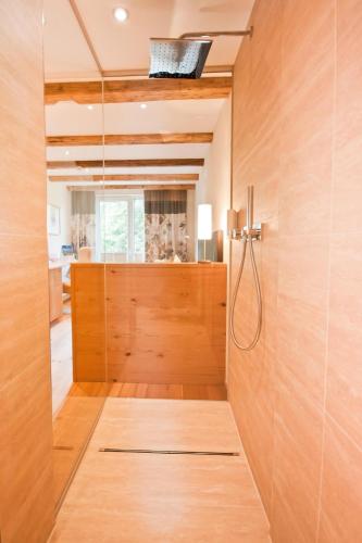 a bathroom with a shower with a wooden door at Hotel Riederhof- Urlaub mit WAU! in Ried im Oberinntal