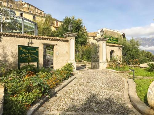a building with a sign in front of a garden at Villa San Domenico in Morano Calabro