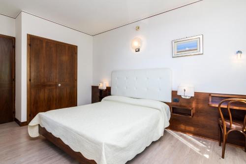a bedroom with a white bed and a wooden desk at Hotel San Marco in Montebelluna