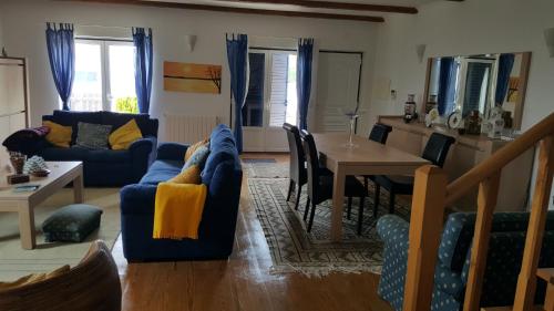 a living room with a blue couch and a table at Villa da Praia Azul in Silveira