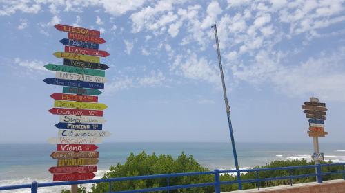 a bunch of street signs in front of the ocean at Villa da Praia Azul in Silveira