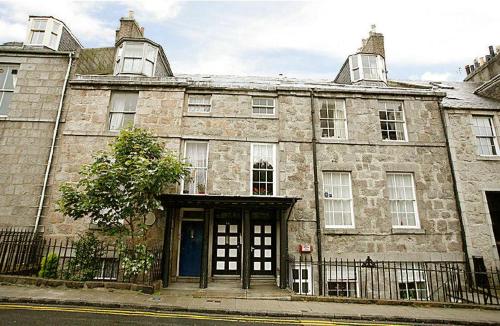 an old stone building with a door on a street at Skene Terrace Apartments in Aberdeen
