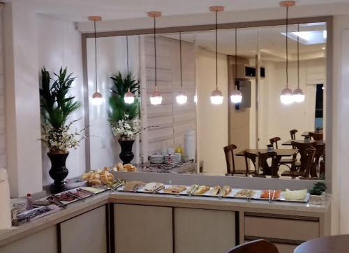 a restaurant with a counter with pastries on it at Hotel Vizzion in Paraí