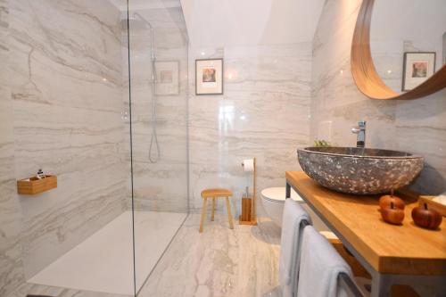 een badkamer met een wastafel en een glazen douche bij Apartmaji 43 in Tolmin