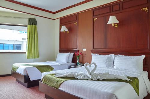 ein Hotelzimmer mit 2 Betten mit Herz darauf in der Unterkunft MIDO Hotel in Bangkok