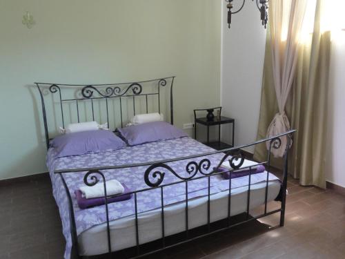 een slaapkamer met een metalen bed met paarse kussens bij Apartma Jezero in Most na Soči