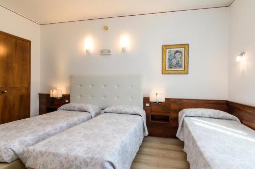 a room with three beds and a picture on the wall at Hotel San Marco in Montebelluna