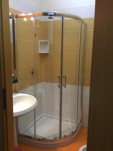 prysznic ze szklanymi drzwiami obok umywalki w obiekcie Hotel Vittorio w mieście Portopalo