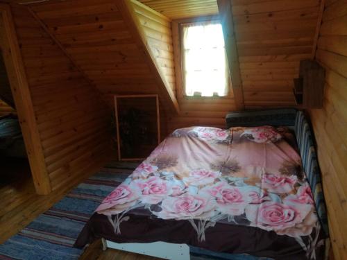 1 cama en el ático de una cabaña de madera en Brīvdienu māja Strazdi, en Ugāle