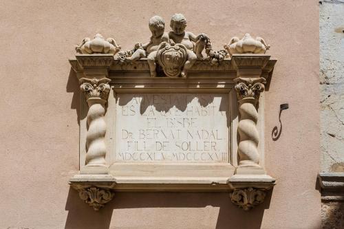 a sign on the side of a building at Hotel Ca'l Bisbe in Sóller
