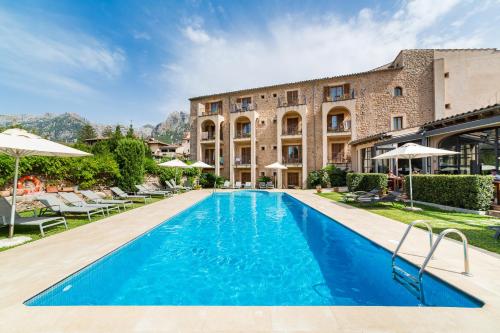 a large swimming pool in a large house at Hotel Ca'l Bisbe in Sóller