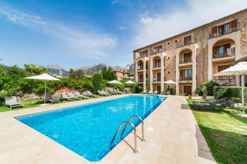 a swimming pool in front of a building at Hotel Ca'l Bisbe in Sóller