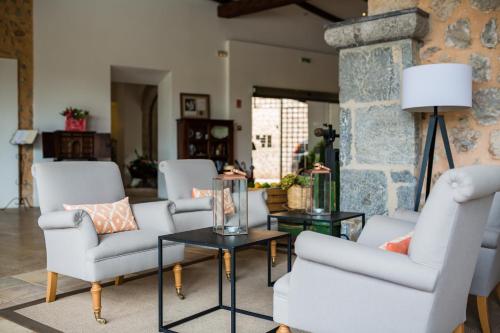 a living room with white chairs and a table at Hotel Ca'l Bisbe in Sóller