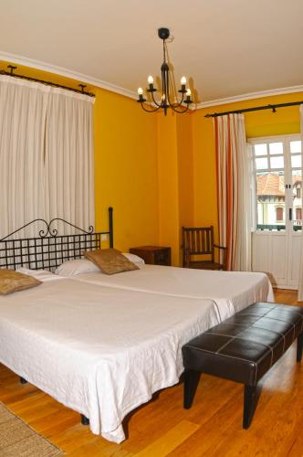 two beds in a room with yellow walls at Hotel Rural Isasi in Gordexola