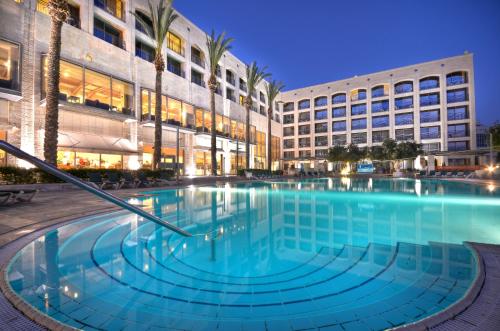 a large swimming pool in front of a building at Golden Crown Hotel in Nazareth