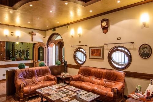a living room with two leather couches and a table at Hotel San Marco in Montebelluna