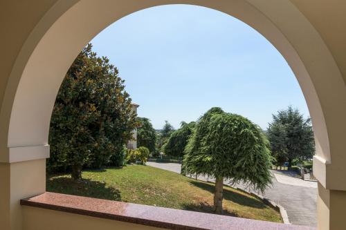 an archway in a building looking out at a tree at Hotel San Marco in Montebelluna