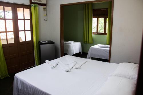 a bedroom with two beds and a mirror at Pousada da Mata in Iriri