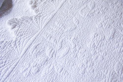 a close up of a white mattress with patterns on it at Pousada da Mata in Iriri