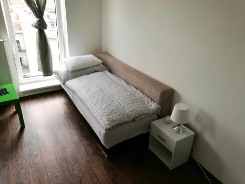 a small couch in a room with a window at Haas Apartments Downtown with Parking in Brno