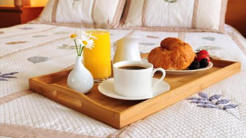 a tray with a cup of coffee and a plate of food on a bed at B&B Stazione Latina in Sermoneta