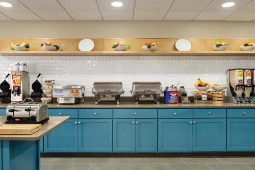 a kitchen with blue cabinets and plates on the wall at Country Inn & Suites by Radisson, Coralville, IA in Coralville