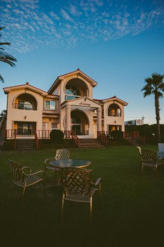 a house with a table and chairs in front of it at Jennyville Pension in Seogwipo