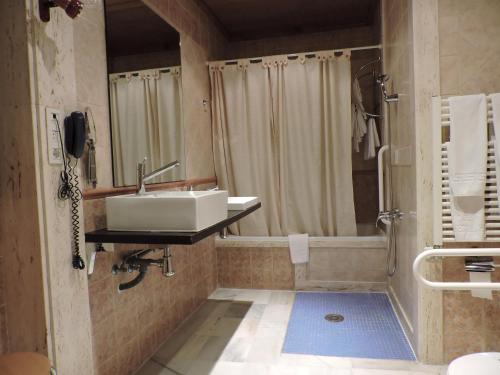 y baño con lavabo y ducha. en Hotel Palacio de Oñate, en Guadix