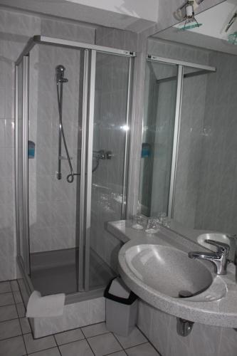 a bathroom with a shower and a sink and a shower at Hotel Roemerstein in Mainz