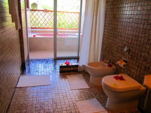 a bathroom with a toilet and a sink and a tub at Badian Island Wellness Resort in Badian