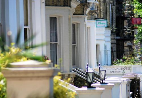 una fila de edificios blancos con un cartel en una calle en OYO Albany, Brighton & Hove en Brighton & Hove