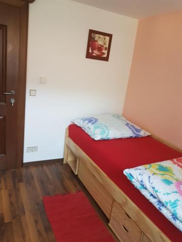 a bedroom with two beds and a red mattress at Pension Haus Rohrmoser in Annaberg im Lammertal