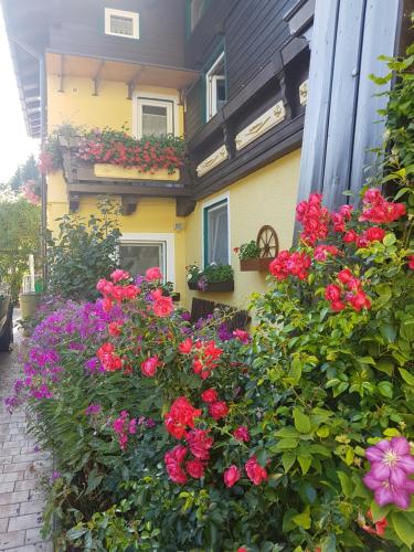 a flower garden in front of a house with flowers at Pension Haus Rohrmoser in Annaberg im Lammertal