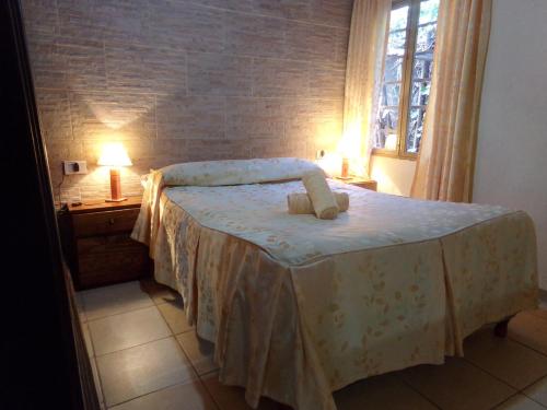 a bedroom with a bed with two lamps and a window at Cabañas El Challao in Mendoza