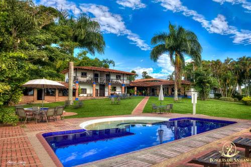 una casa con piscina frente a un patio en Hotel Bosques Del Saman Alcala, en Quimbaya
